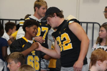 Future Football Star Shaking Hands With Senior Football Player
