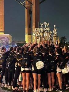 2022 RhythaMetteS huddle with trophies