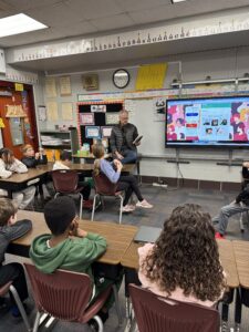 Randy Mohning, previous Four Mile principal, reading to Four Mile students.