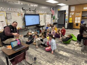 Board member Grant Gillon reading to Four Mile first graders