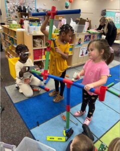 Preschool students doing "construction" with plastic pipes
