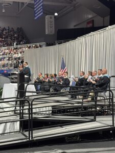 Pettit, Halupnik, Leadership and Board on Graduation stage clapping 2026