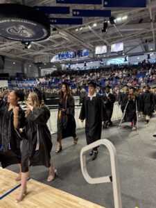 Graduates waving to family as class exits ceremony 2026