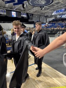 2026 Graduate getting a handshake as exiting