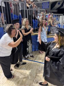 2026 Gracuate high fiving Special Education Associate Ashley Frantz