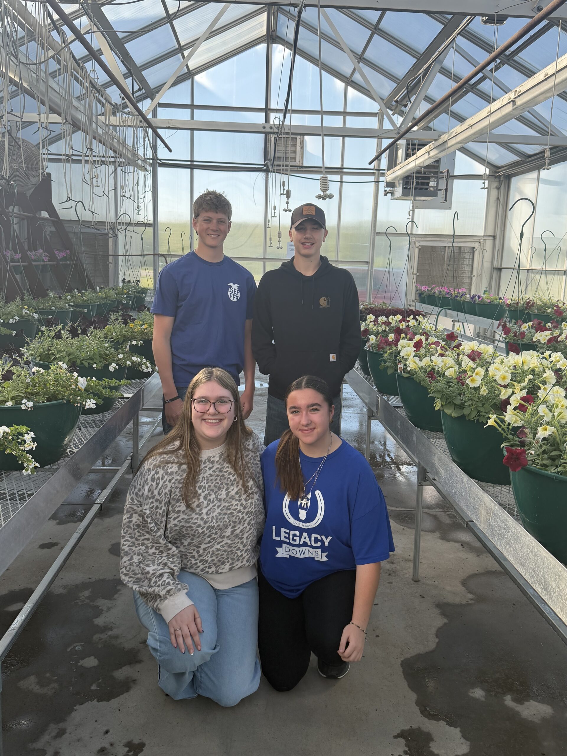 IMG_6232 Picture: Left - Right Back Row: Nico Dixon & Tanner Thompson Front Row: Caitlynn Noe & Jenna Vitek Students in Advanced Horticulture learn how to care for & manage a greenhouse. These students are taking a minute to pose with their hard work before opening morning of the annual plant sale.