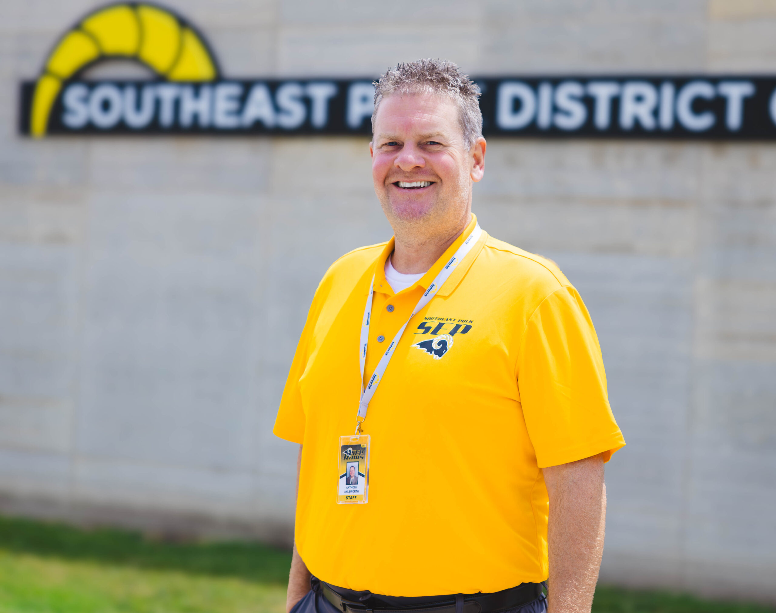 A portait photo of Dr. Tony Aylworth standing in front of the SEP District office.