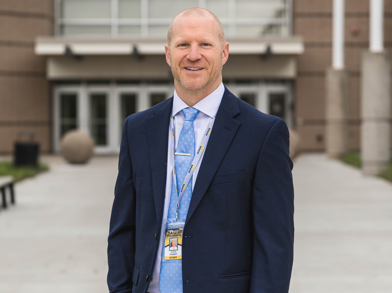 Photo headshot of Dr. Colbert in front of SEP High School.