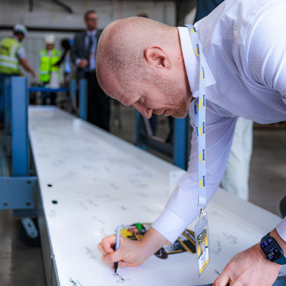 Dr. Justin Colbert, SEP Deputy Supt. signs a structural beam as part of the Topping-out ceremony.